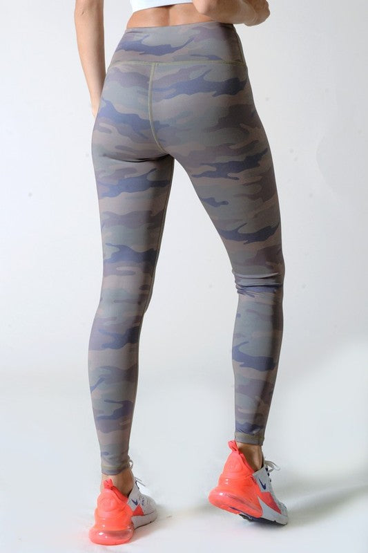 Camouflage leggings worn by a person on a white background