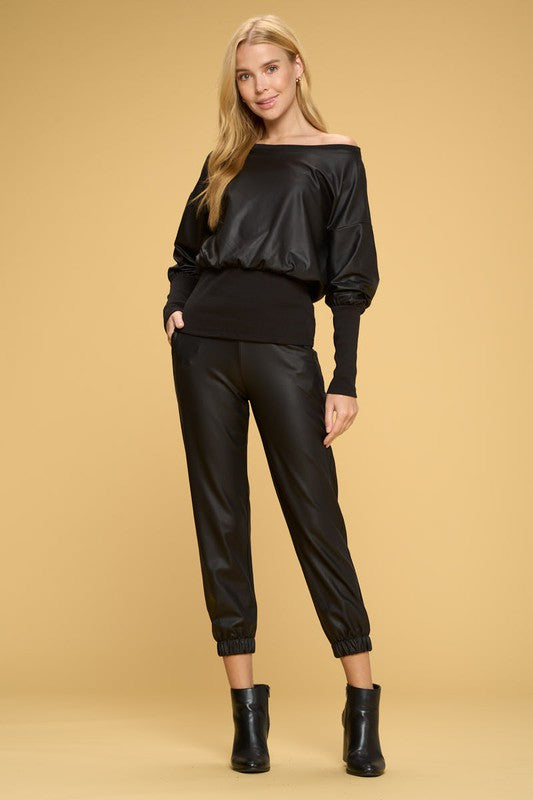 Woman wearing a black outfit with a plain background