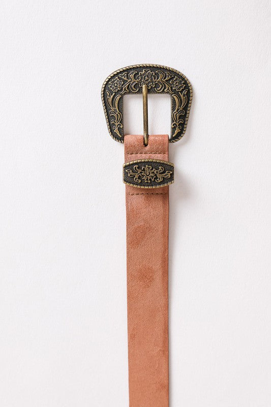 Pink belt with an ornate buckle on a white background