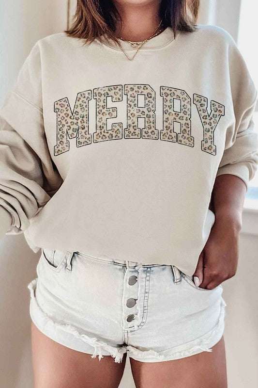 Person wearing a beige sweatshirt with 'MERRY' in leopard print and light denim shorts.