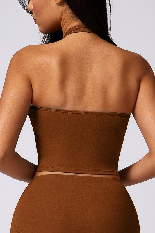 Brown strapless top worn by a person on a plain background