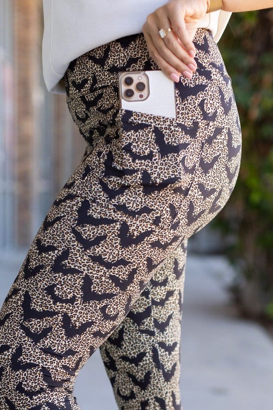 Patterned pants with a phone case in the pocket, worn by a person.