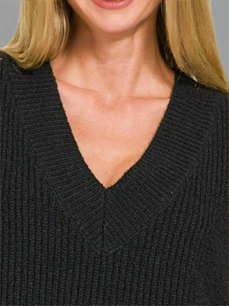 Close-up of a person wearing a black sweater with a V-neck