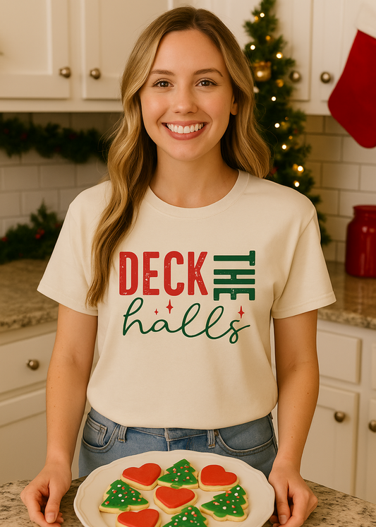 small size model in off white tee with words "deck the halls" in kitchen with cookies