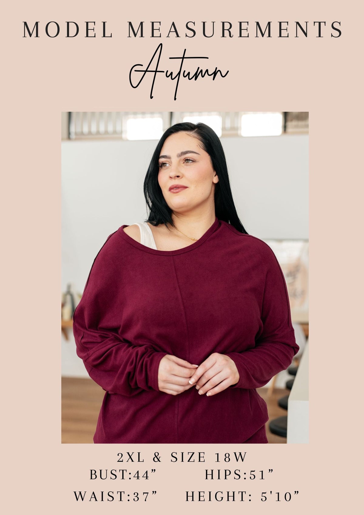 Woman wearing a burgundy dress with model measurements displayed below.