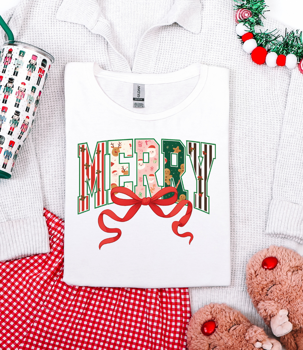 White t-shirt with 'MERRY' print on a white background with Christmas decor.