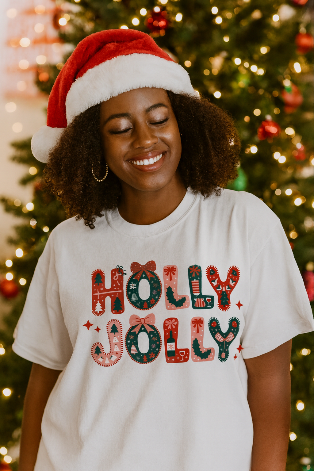 Person wearing a 'Holly Jolly' shirt with a Christmas tree in the background