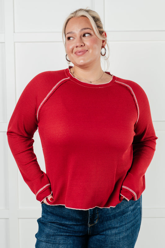 Person wearing a red sweater with white trim against a white background
