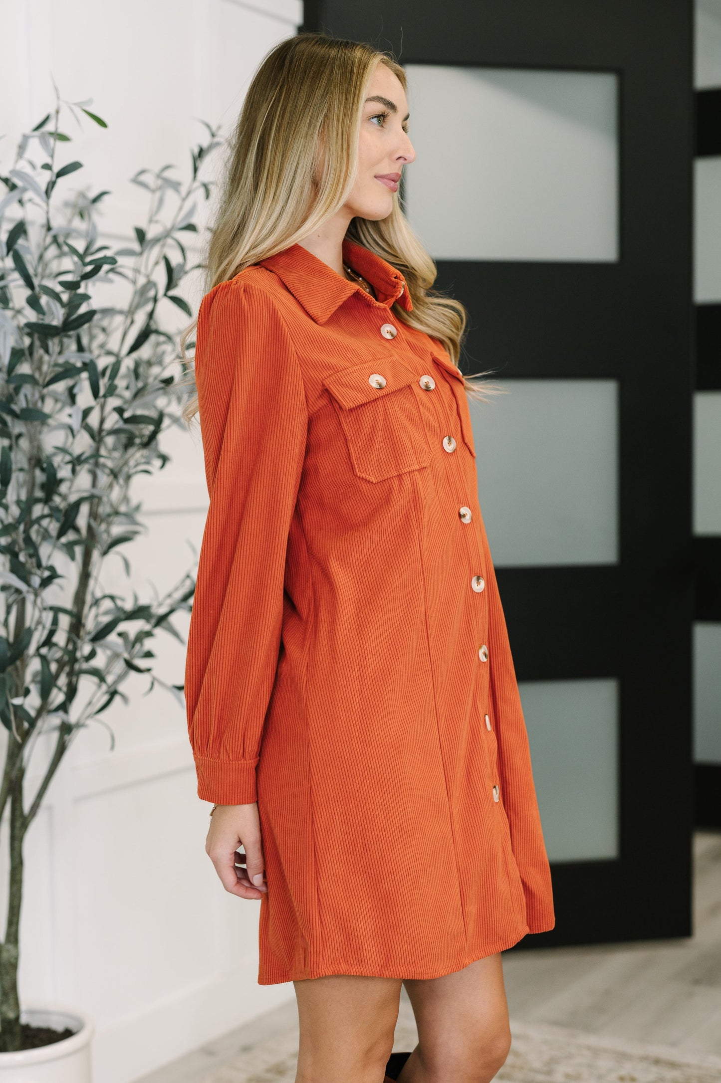 Woman wearing an orange dress with buttons indoors