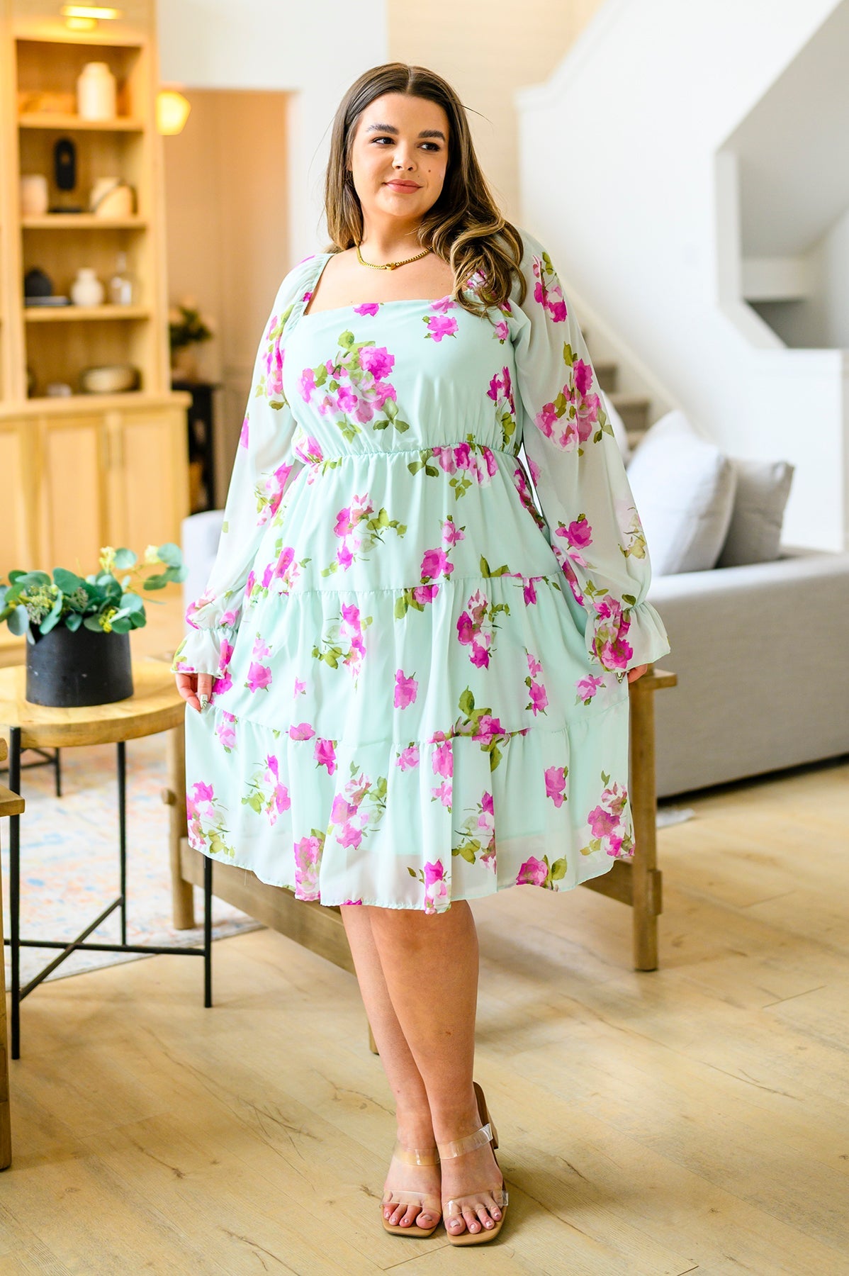Woman wearing a floral dress in a living room setting