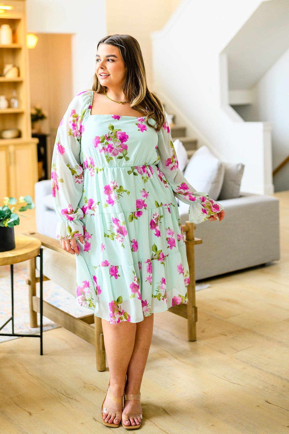 Woman wearing a floral dress in a living room setting
