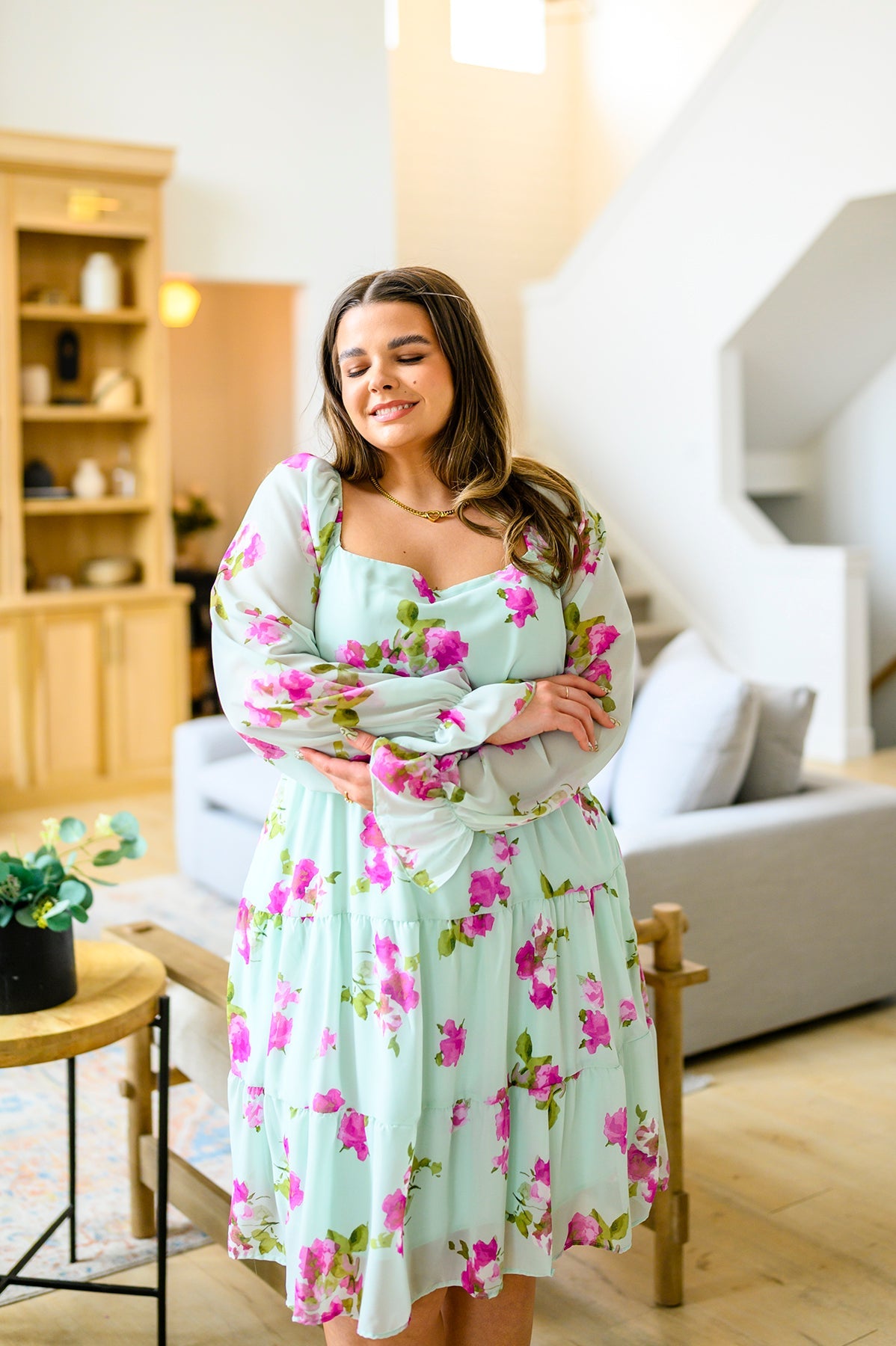 Woman in a floral dress standing in a living room