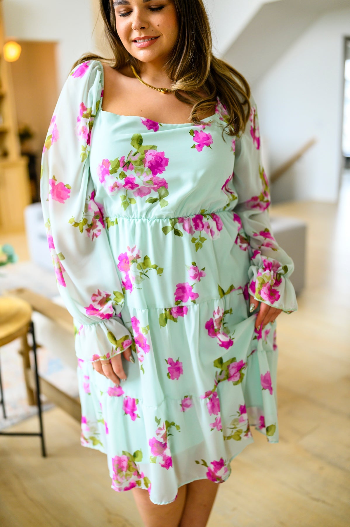 Woman wearing a light blue floral dress in an indoor setting