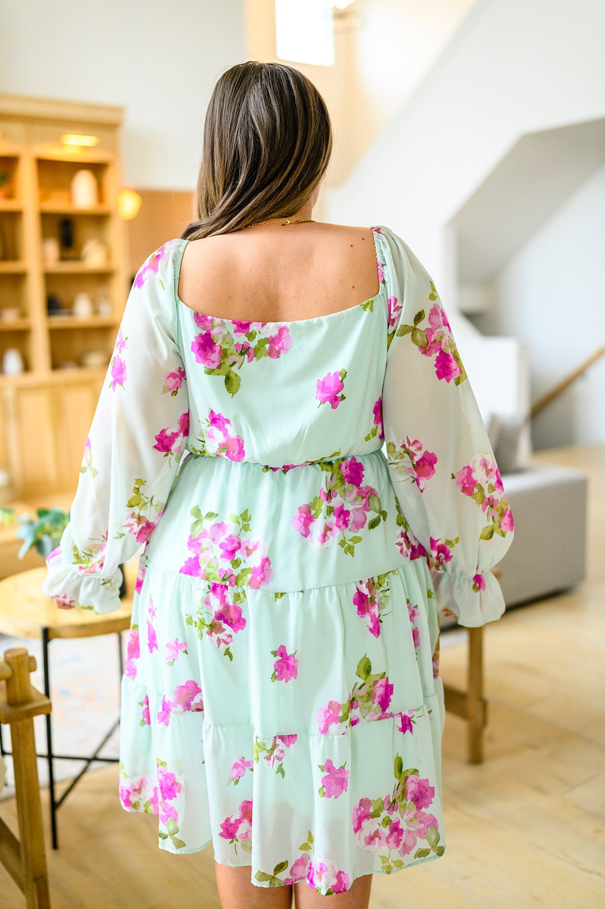 Woman wearing a floral dress in a home setting