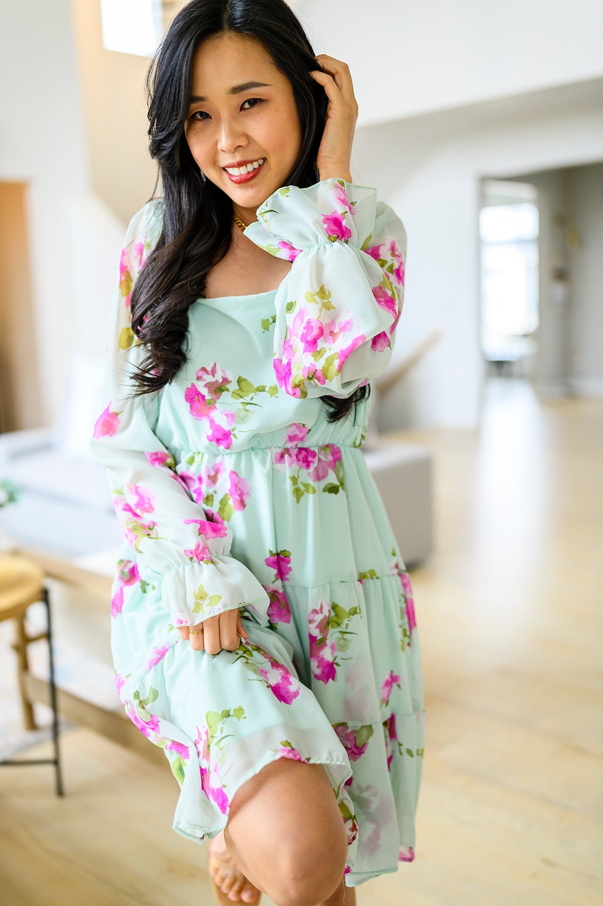 Woman wearing a light blue dress with floral patterns indoors