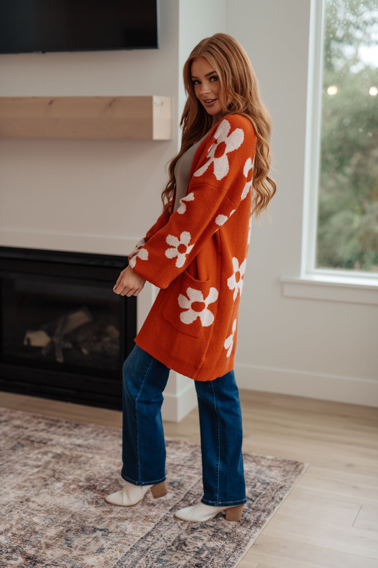 Woman wearing a floral cardigan in a home setting