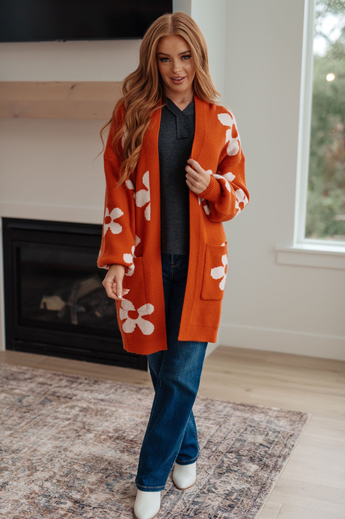 Woman wearing an orange floral cardigan in a home setting