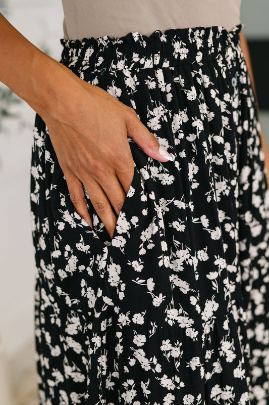 Black floral patterned skirt with a hand in the pocket