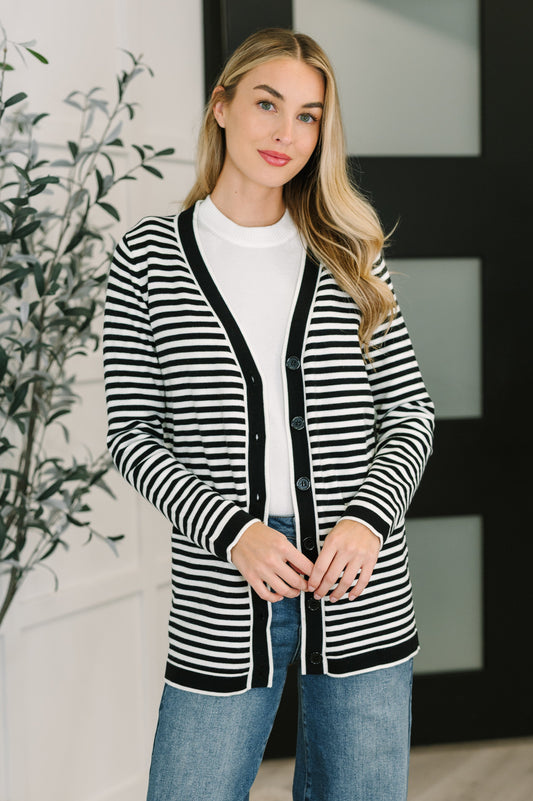 Woman wearing a black and white striped cardigan in an indoor setting