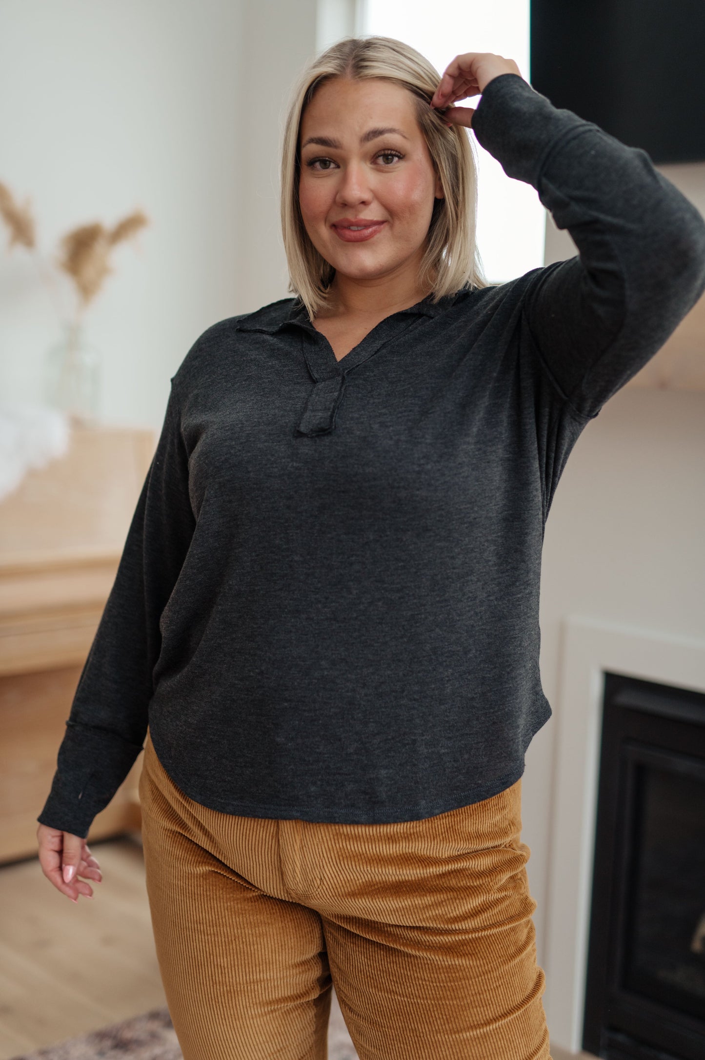Person wearing a dark gray hoodie and mustard yellow pants indoors.