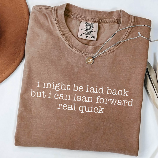 Folded brown sweatshirt with humorous text on a white surface