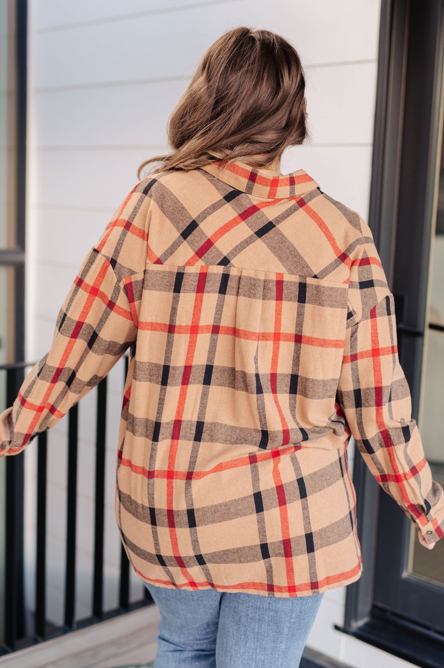Person wearing a plaid shirt with a neutral background
