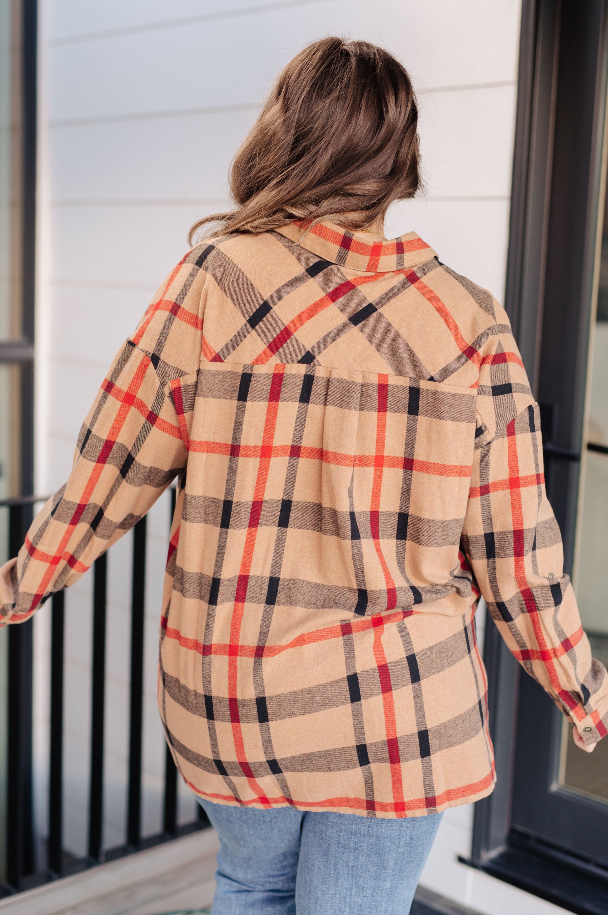 Person wearing a plaid shirt with a neutral background