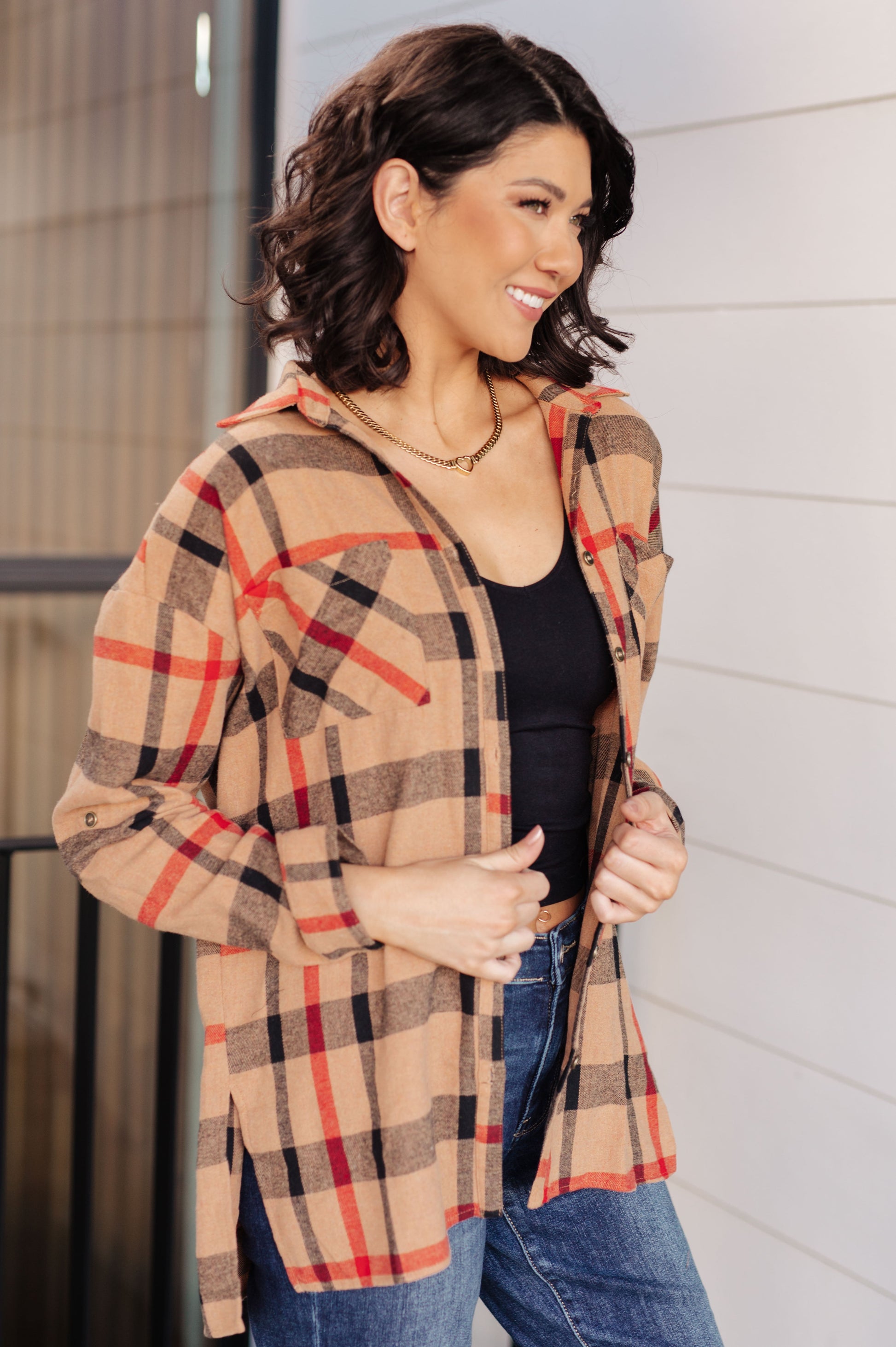 Woman wearing a plaid jacket with a neutral background