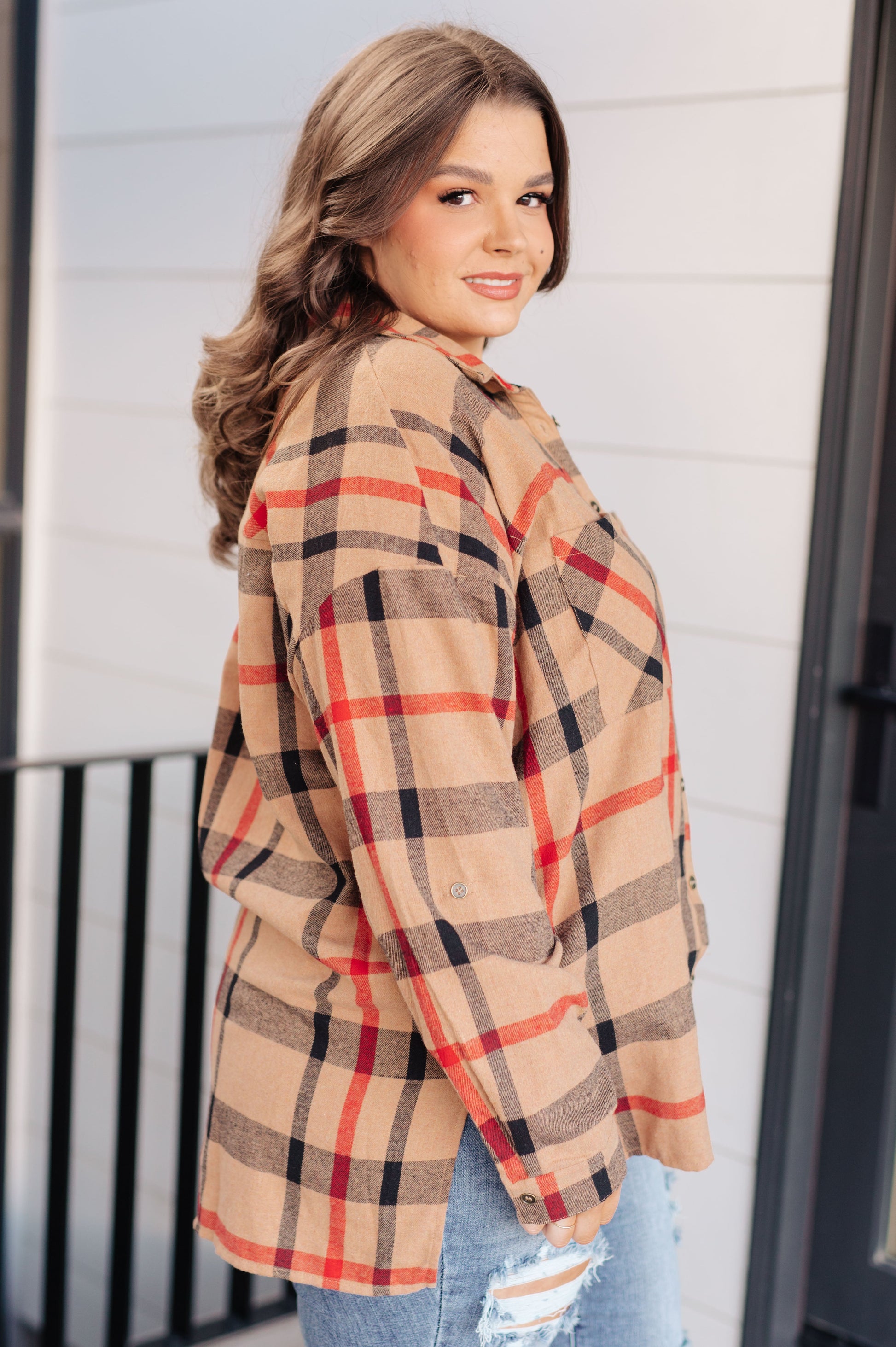 Woman wearing a plaid shirt with a neutral background