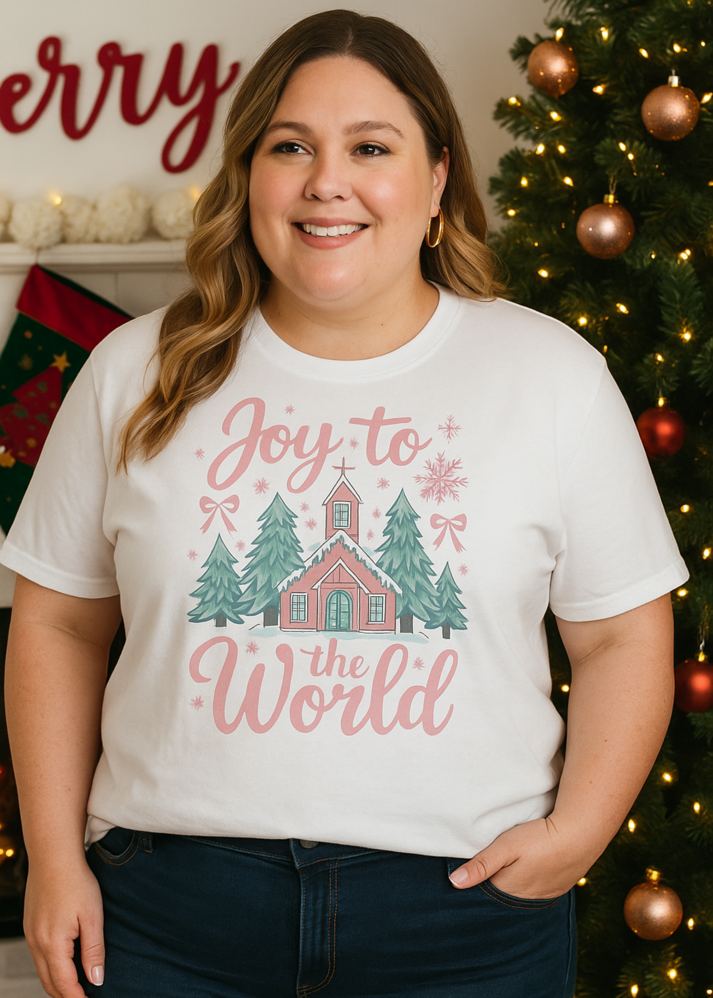 Woman wearing a 'Joy to the World' t-shirt in front of a decorated Christmas tree.