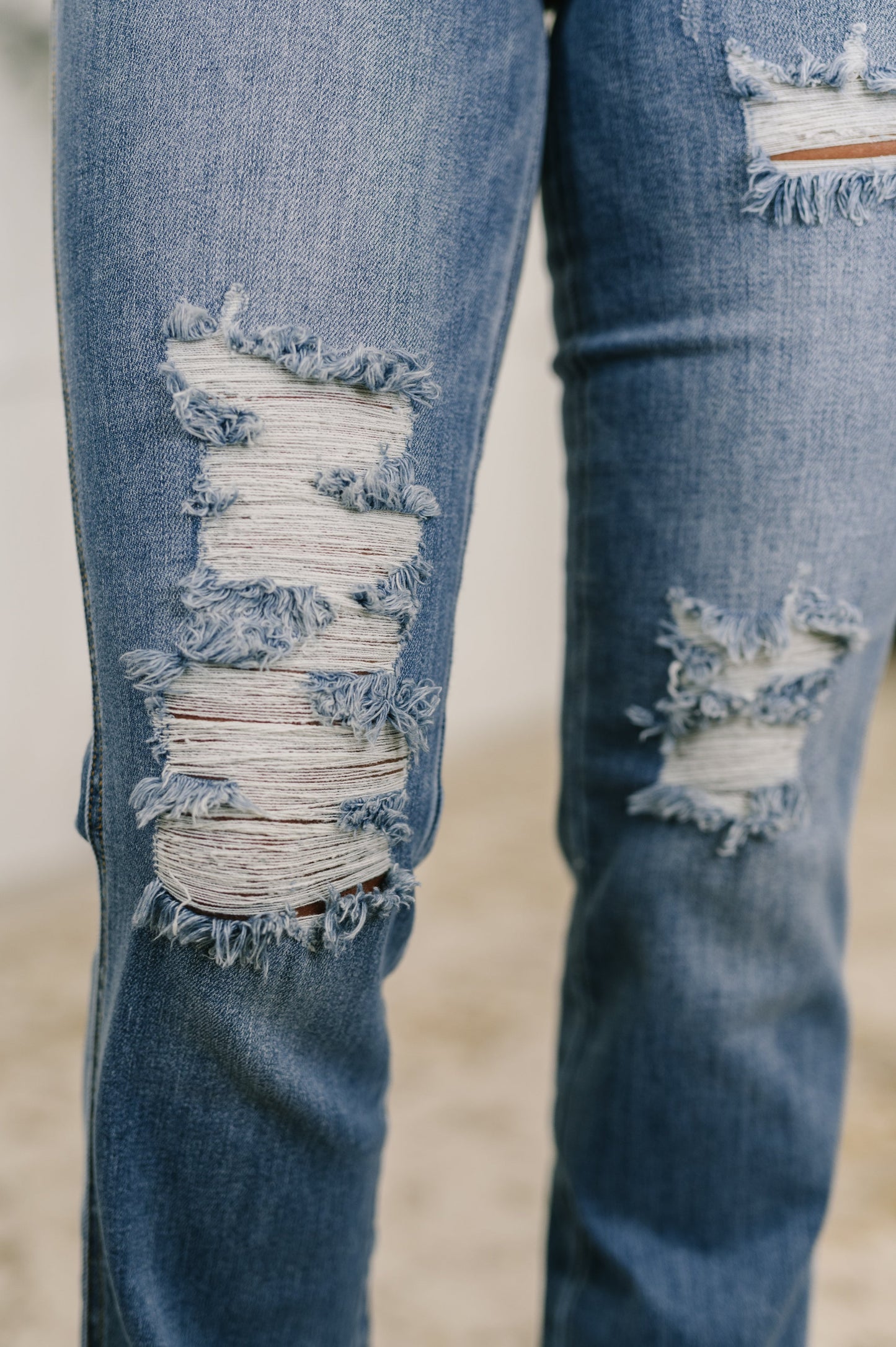 Close-up of distressed blue jeans on a blurred background