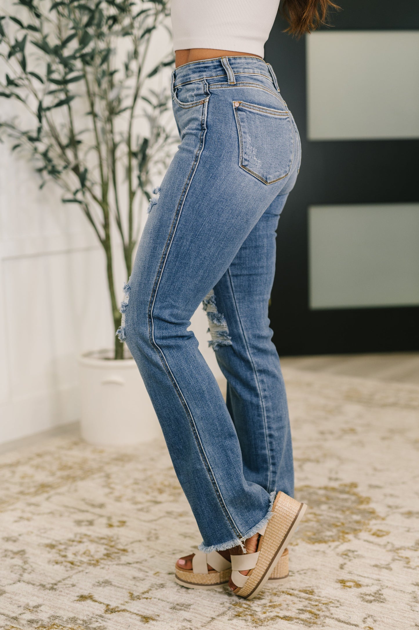 Person wearing blue jeans with a blurred indoor background