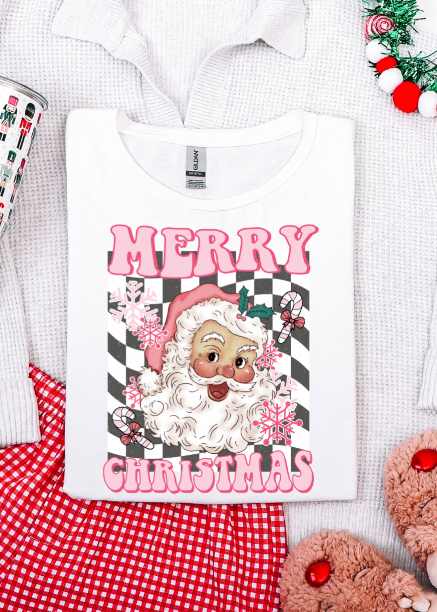 Christmas-themed t-shirt with Santa Claus design and 'Merry Christmas' text, surrounded by festive items.