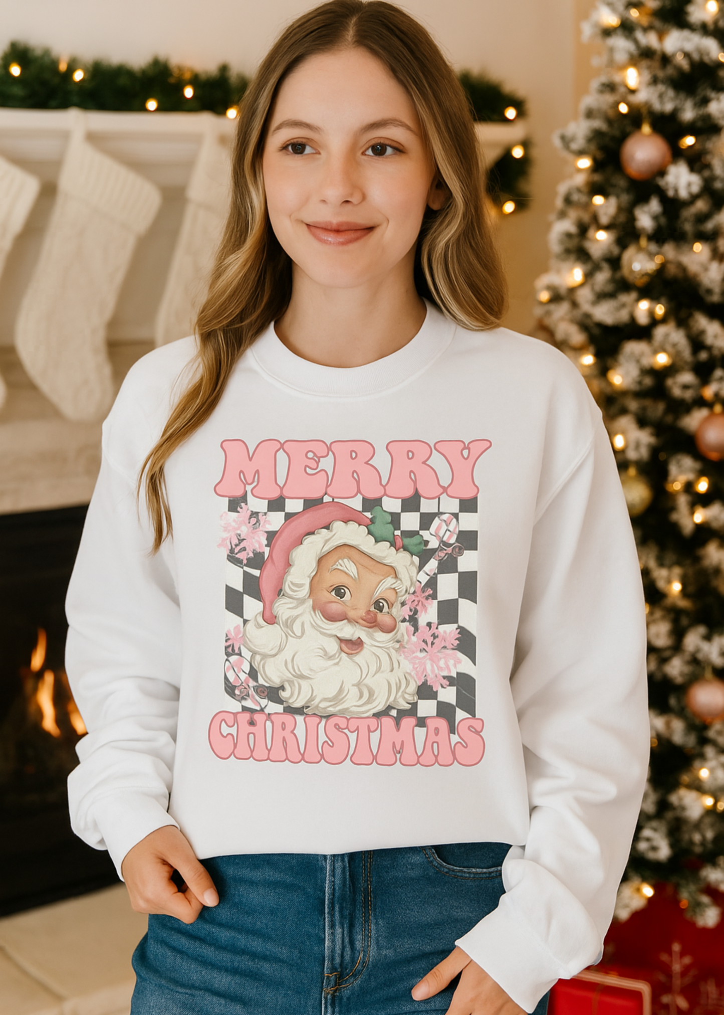 Person wearing a white sweatshirt with a Christmas design in a festive setting with a tree and fireplace.