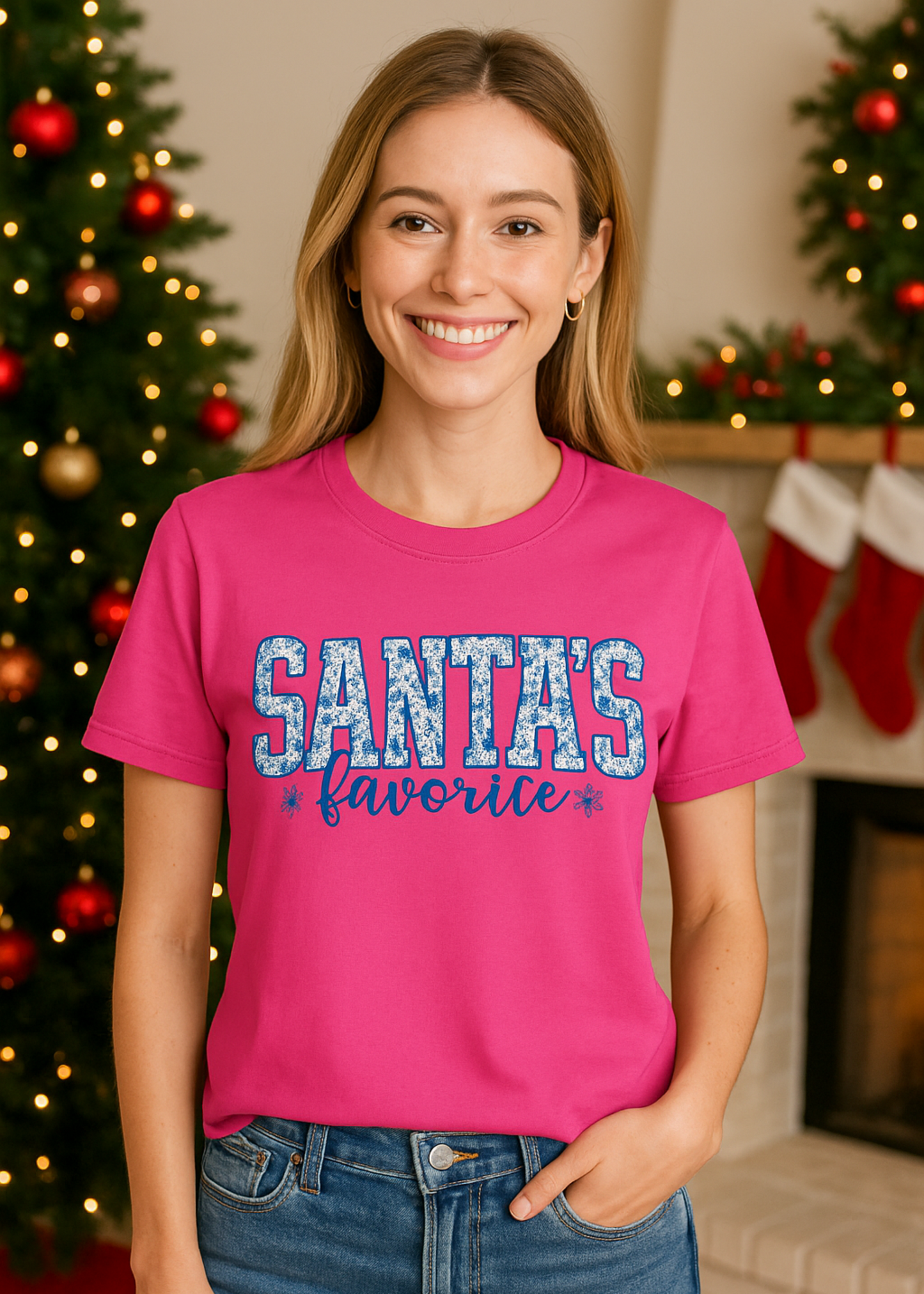 Woman wearing a pink t-shirt with 'Santas Favorite' text in a festive setting.