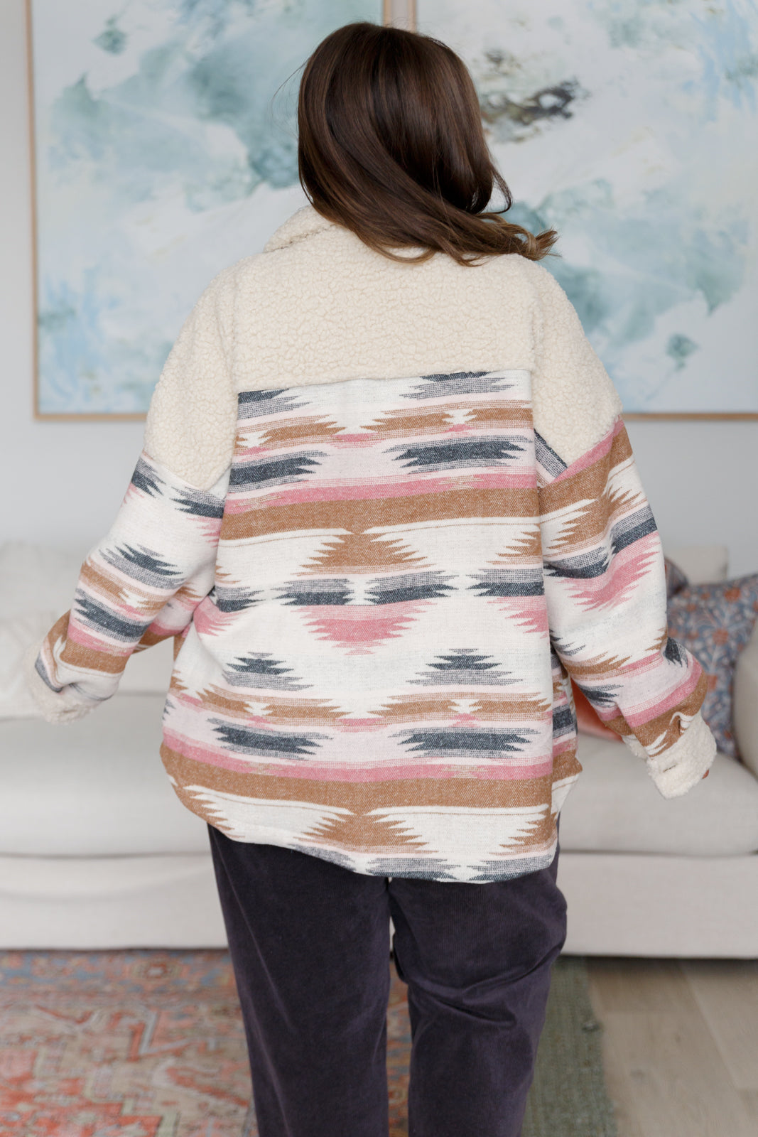 Person wearing a patterned sweater in a living room setting