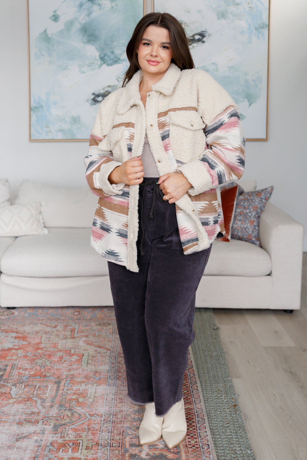 Woman wearing a patterned jacket in a living room setting