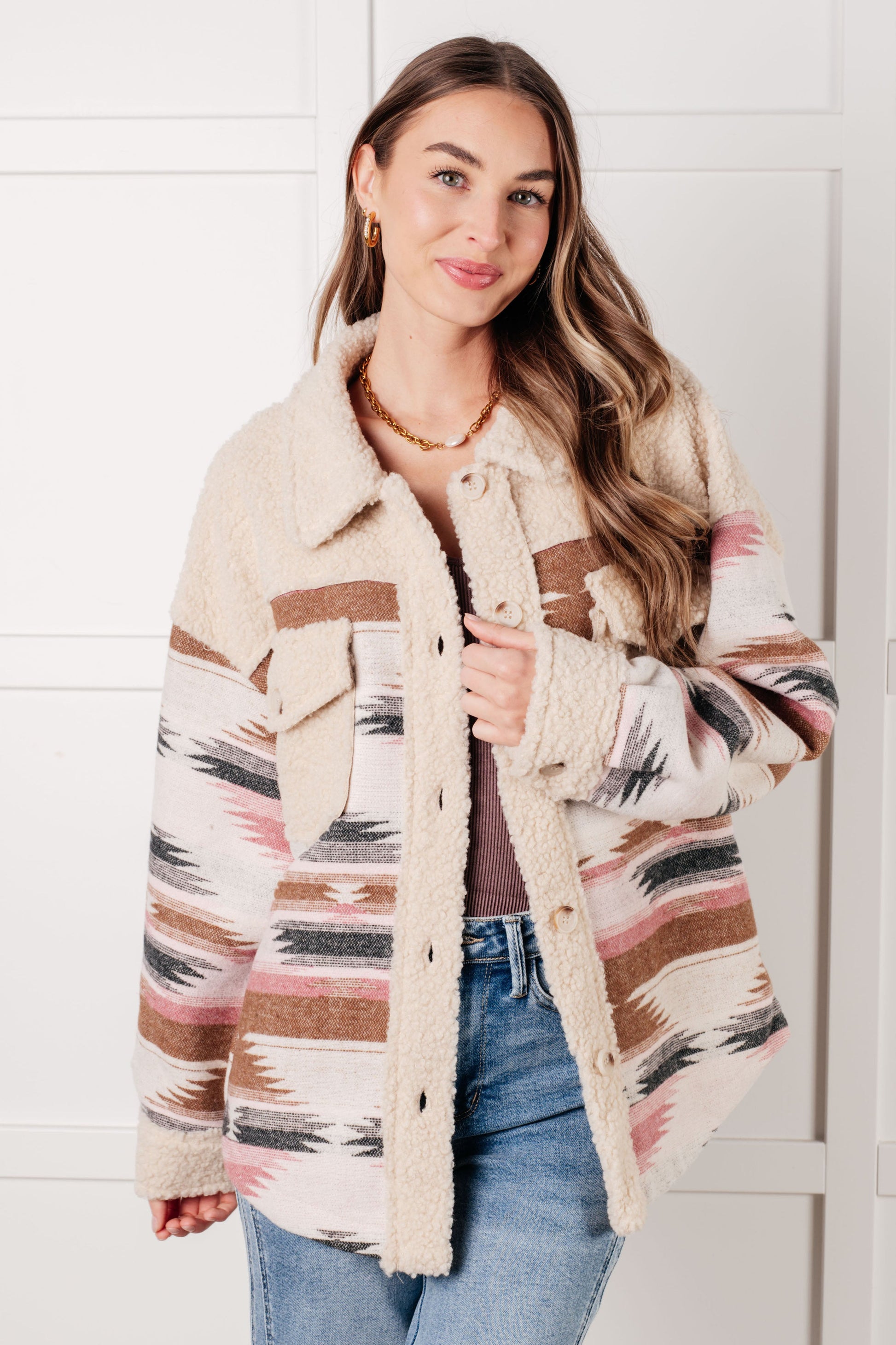 Woman wearing a patterned cardigan with a white background
