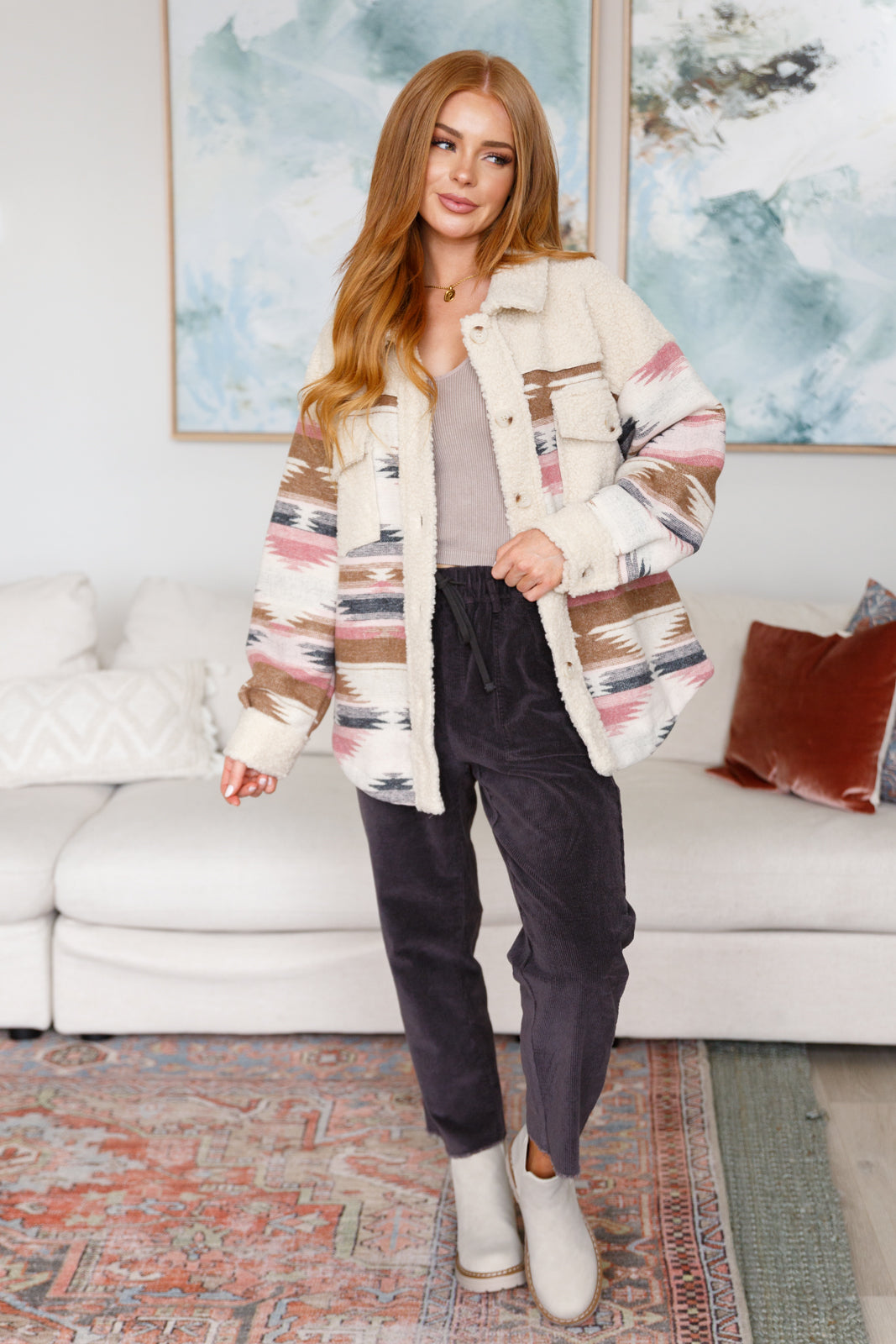 Woman wearing a patterned jacket in a living room setting