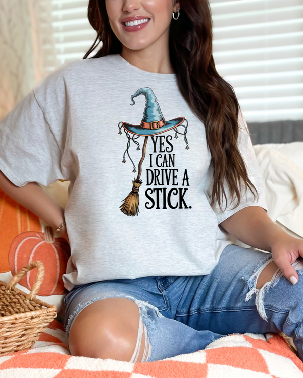 Person wearing a white t-shirt with a Halloween-themed design, sitting on a couch.