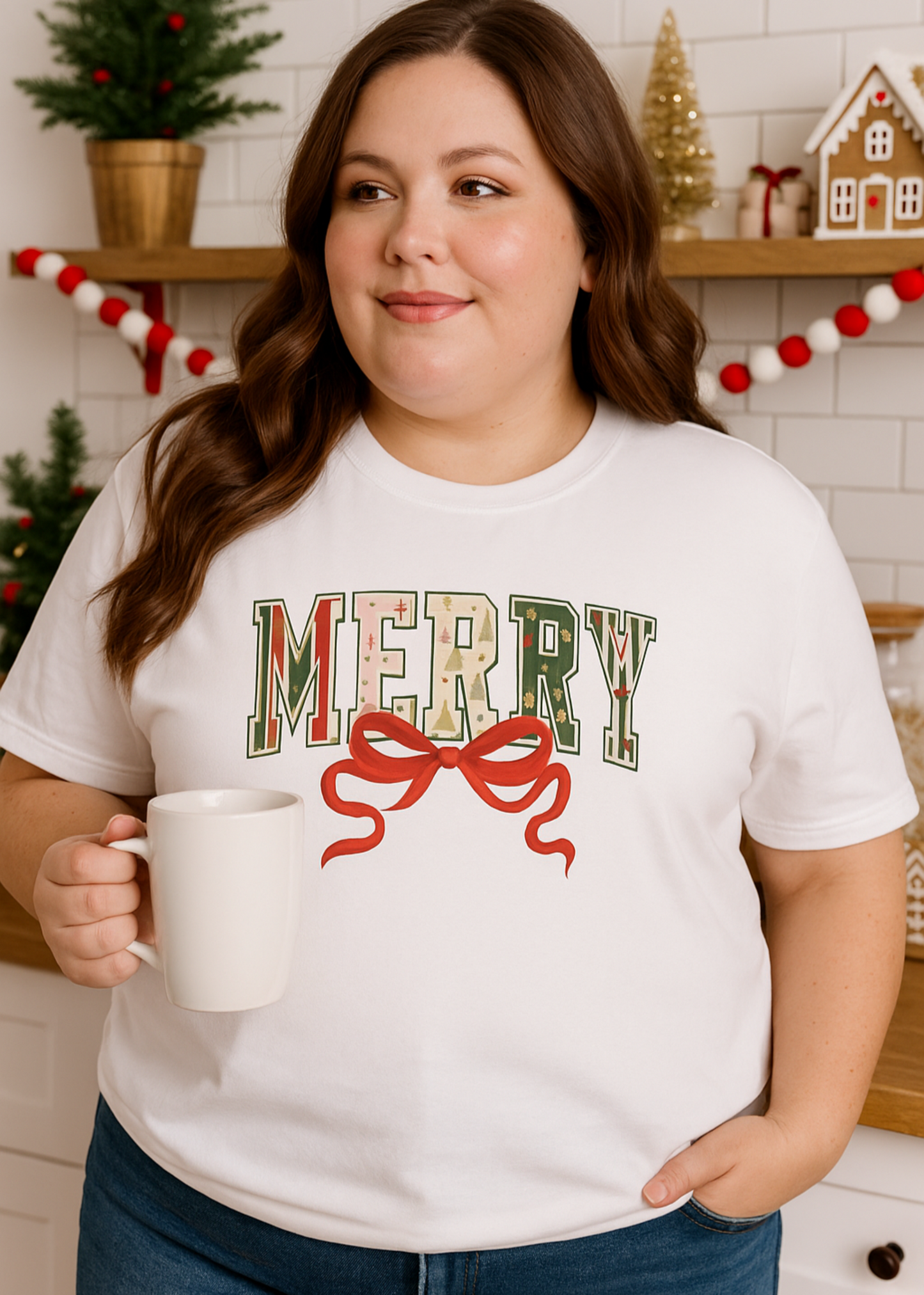 Woman wearing a 'Merry' Christmas shirt holding a mug in a festive kitchen.
