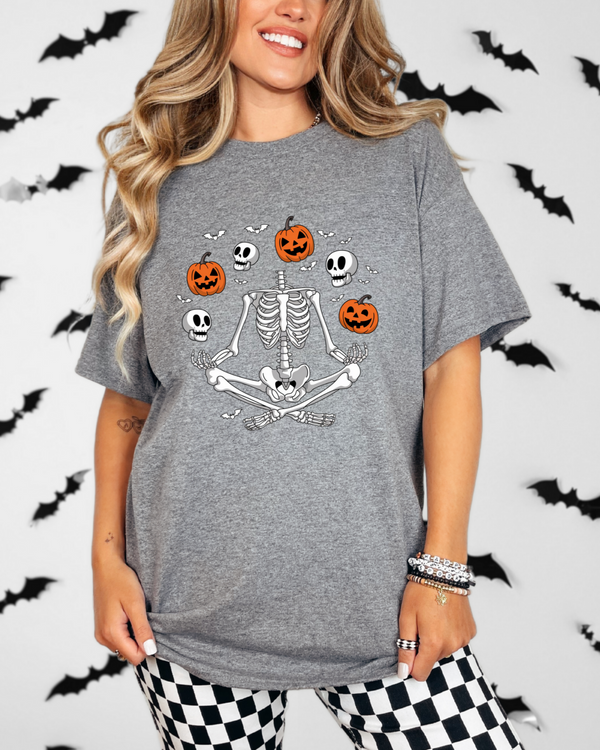 Person wearing a gray t-shirt with Halloween-themed design against a bat-patterned background