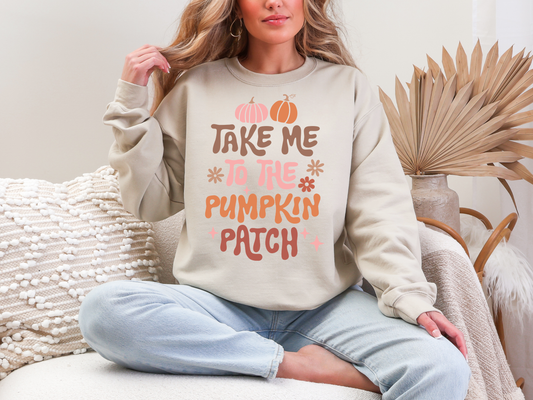 Person wearing a beige sweatshirt with 'Take Me to the Pumpkin Patch' text, sitting on a white couch.