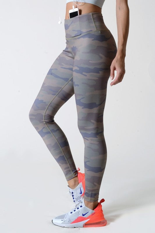 Camouflage leggings worn by a person on a white background