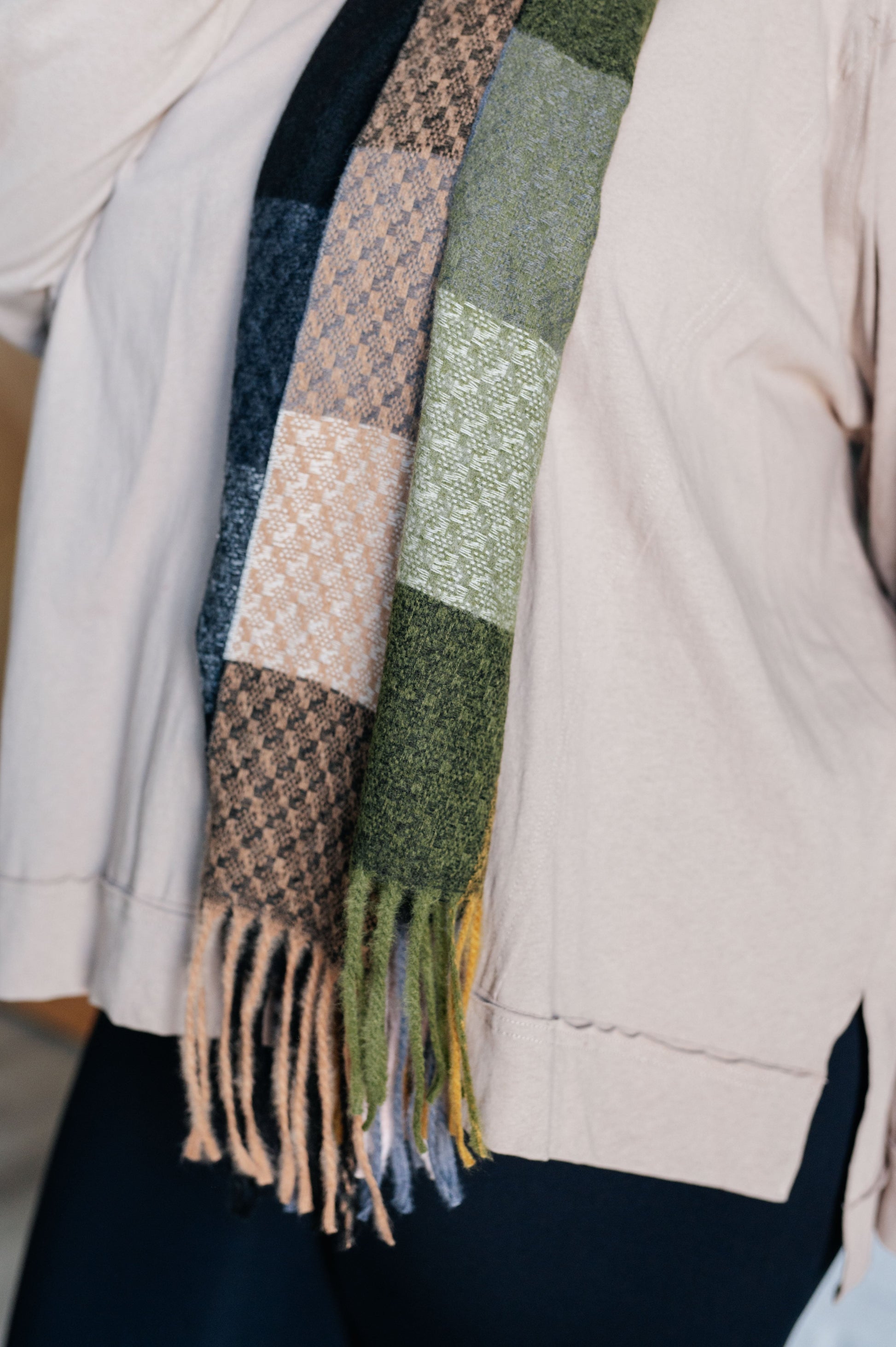 Close-up of a person wearing a patterned scarf with a neutral background