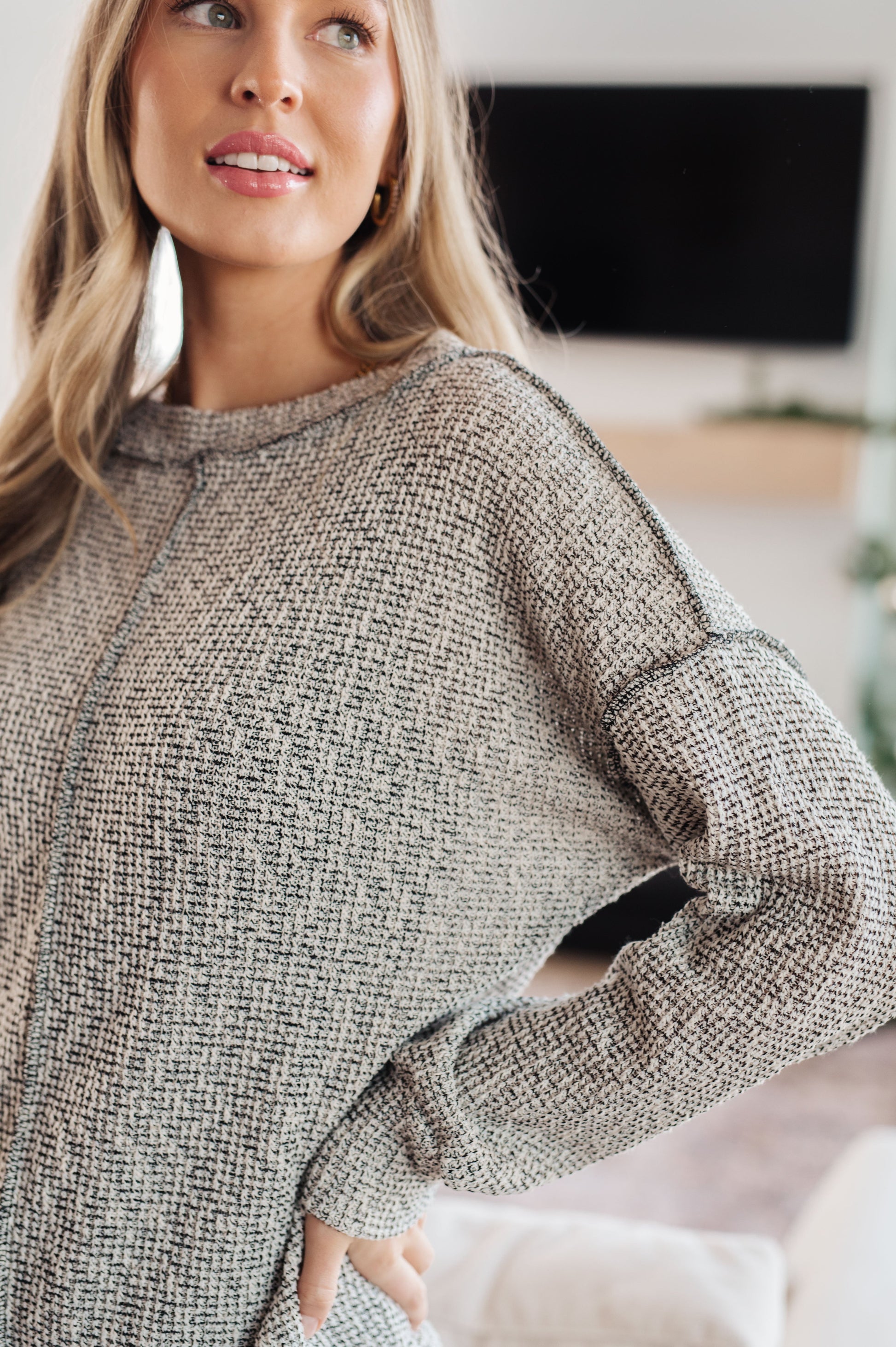 Woman wearing a textured sweater in an indoor setting