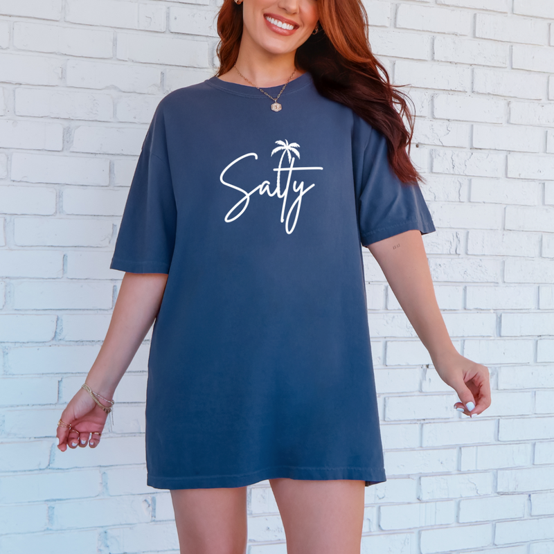 A person wearing a gray graphic tee with the word 'Salty' printed on the front in a white cursive font.