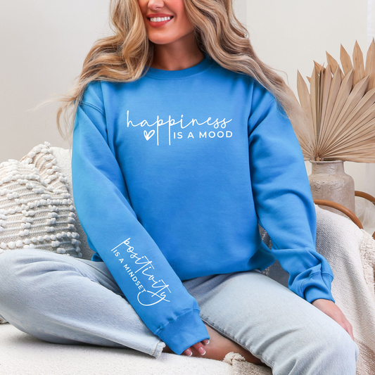 Person wearing a blue sweatshirt with text, sitting on a couch.