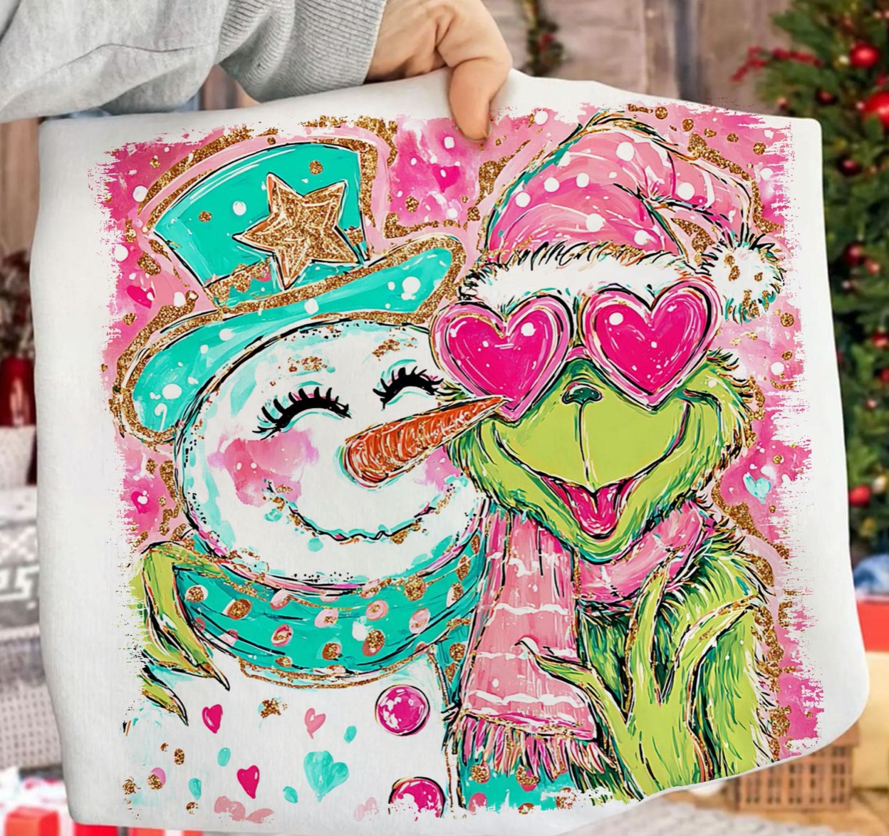 Colorful tote bag with a snowman and green character design, held by a person.