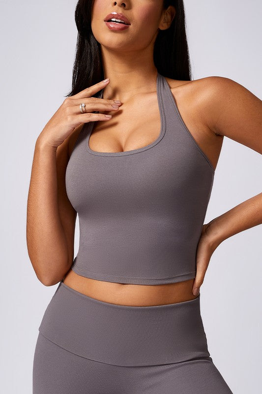 Woman wearing a gray athletic outfit against a plain background